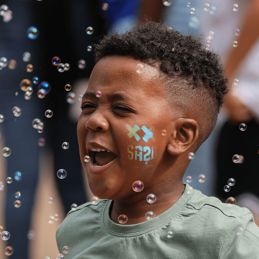 Young fan with SA20 face paint surrounded by bubbles